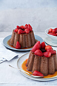 Gebackener, gekühlter Schokoladenpudding mit Erdbeeren und Karamellsauce