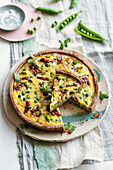 Dinkel-Buchweizen-Quiche mit Erbsen, Saubohnen, Speck und Minze