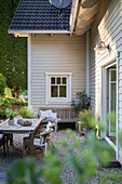 View of terrace with table and bench in front of house with wooden paneling