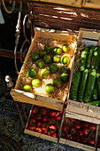 Limes, zucchini and tomatoes in wooden boxes