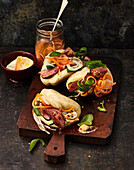 Sticky pigeon breast with pickled carrots in bao buns