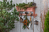 Weihnachtsdeko auf der Terrasse mit Tannenzweigen und Weihnachtsstern an rustikaler Garderobe hängend