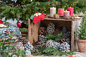 Weihnachtsdeko, Kerzen und bemalte Zapfen vor geschmücktem Christbaum