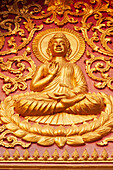 Laos, Luang Prabang. Golden relief carving of Buddha.