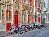 Belgien, Brügge. Fahrräder entlang der Straße geparkt.