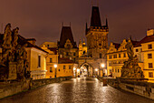 Arch of Lesser Town Bridge Tower on Charles Bridge with St. Nicholas Church in Prague, Czech Republic