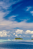 Französisch-Polynesien, Moorea. Verankerte Boote und kleine Insel.