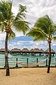 French Polynesia, Moorea. Overwater bungalows and hammock.