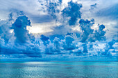 Wolkenlandschaft, Moorea, Tahiti, Französisch-Polynesien. Verschiedene Blautöne im Wasser der Lagune und der Korallenriffe