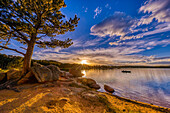 USA, Colorado, Dowdy Lake. Sonnenuntergang auf dem See und Menschen, die in einem Boot angeln.
