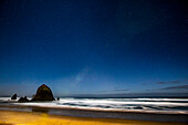 USA, Oregon. Cannon Beach and Haystack Rock stars showing during blue light.