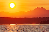 Sonnenuntergang über dem Puget Sound, Seattle, Bundesstaat Washington. Silhouette des The Brothers Peak rechts.