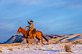 USA, Wyoming. Hideout Horse Ranch, Wrangler und Pferd im Schnee (MR,PR)