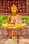 Laos, Luang Prabang. Golden Buddha statue and altar.