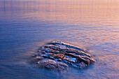 Canada, Manitoba, Paint Lake Provincial Park. Paint Lake. Exposed rock on Paint Lake at sunrise.