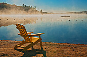 Kanada, Ontario, Silent Lake Provincial Park. Muskoka-Stuhl und Morgennebel am Silent Lake.