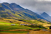 Mountains towering over Oxnadalur with road climbing up to Oxnadalsheidi. Europe, Iceland