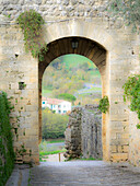 Italien, Chianti, Monteriggioni. Blick durch einen gewölbten Eingang in die ummauerte Stadt.