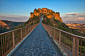 Italy, Tuscany. Evening light of Civita di Bagnoregio and the long bridge leading to town.
