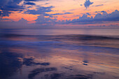 USA, Georgia, Tybee Island. Sonnenaufgang mit Wolken und Spiegelungen an der Küste.