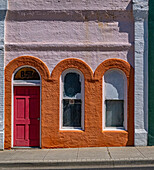 USA, Bundesstaat Washington, Pomeroy. Buntes altes Gebäude mit gewölbten Fenstern und Türöffnung mit Maßstab