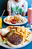 Burger und Pommes frites bei einem Abendessen, die traditionelle amerikanische Mahlzeit; Manhattan, New York, Vereinigte Staaten von Amerika