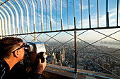 Tourists Enjoying The Views Of Manhattan From The Top Of The Empire State; New York, Usa
