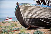 Alte Fischerboote, Netze und Fischerhütten sind ein häufiger Anblick auf den Kiesbänken von Dungeness in Kent, Großbritannien