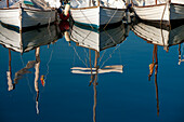 Boote beim Anlegen in einem Hafen mit dem Spiegelbild im ruhigen Wasser; Mallorca, Spanien