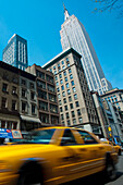 Taxi fährt vor dem Empire State Building vorbei, Manhattan, New York, Usa