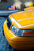 Amerikanische Flagge und gelbes Taxi in Manhattan, New York, USA