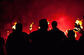 Silhouettes of men with lit torches on Guy Fawkes Day; Newick, East Sussex, England