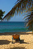 Frau sonnt sich unter Palmen am Magazine Beach; Carriacou Island, Grenada