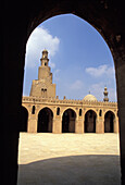 Blick auf Minarett und Innenhof der Ibn Tulun Moschee durch einen Bogen, Kairo, Ägypten; Kairo, Ägypten