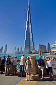 Touristen stehen am Geländer des Burj Khalifa, Dubai, Uae