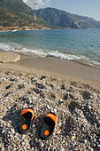 Verlassene Flip Flops an einem Kieselstrand, Nationalpark, Oludeniz an der Türkisküste, Südtürkei