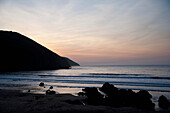 Sonnenuntergang über dem Meer und Strand in Putsborough Sands, Nord-Devon, Großbritannien
