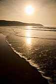 Waves Lapping Up On The Shore At Sunset At Putsborough Sands, North Devon, Uk