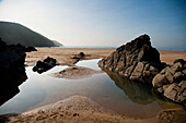 Großer Felsentümpel am Strand umgeben von Felsen in Putsborough Sands, Nord-Devon, Großbritannien