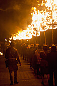People From East Hoathly & Halland Carnival Society Carrying Large Burning Banner Through East Hoathly On Bonfire Night, East Sussex, Uk