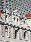 Altes Kolonialgebäude vor einem großen modernen Bürogebäude aus Beton, Kapstadt, Südafrika.
