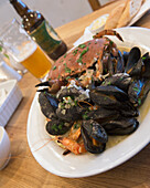 United Kingdom, England, Cornwall, mussels and tiger prawns platter in white wine and cream sauce with salad and bread; Falmouth, Whole crab, Fresh Cornish seafood