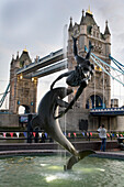 United Kingdom, Girl with Dolphin statue in front of Tower Bridge; London