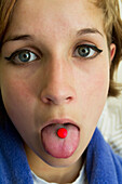 United Kingdom, England, Esher, Teenager with red tablet medicine
