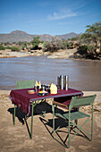 Kenya, Riverside breakfast table set up for guests at Joy's Camp; Shaba National Reserve