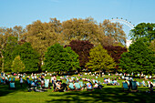 Menschen beim Sonnenbaden an einem Frühlingstag im Green Park, Central London, London, UK