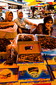 Malaysia, Terengganu, Pasar Payang Zentraler Markt; Kuala Terengganu, Standbetreiberinnen verkaufen Datteln auf einem großen Markt im Innen- und Außenbereich