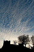 UK, East Sussex, Silhouette of Lewes Castle with mackerel sky behind at dusk; Lewes