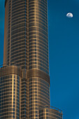 VAE, Detail des Burj Khalifa mit dahinter aufsteigendem Mond; Dubai