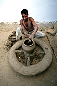 A Man Working On A Pottery Wheel, Potters Village; Madhya Pradesh, India